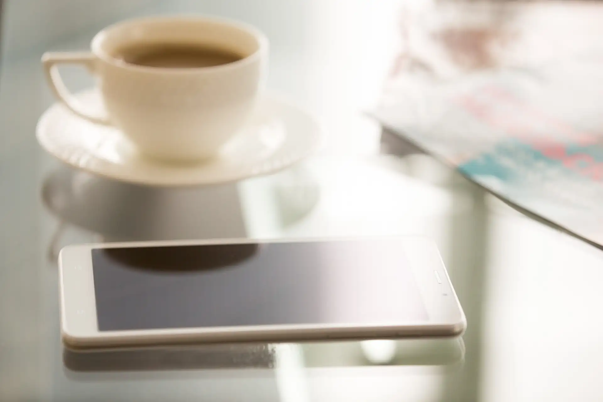 A mobile phone on a windowsill in the evening light