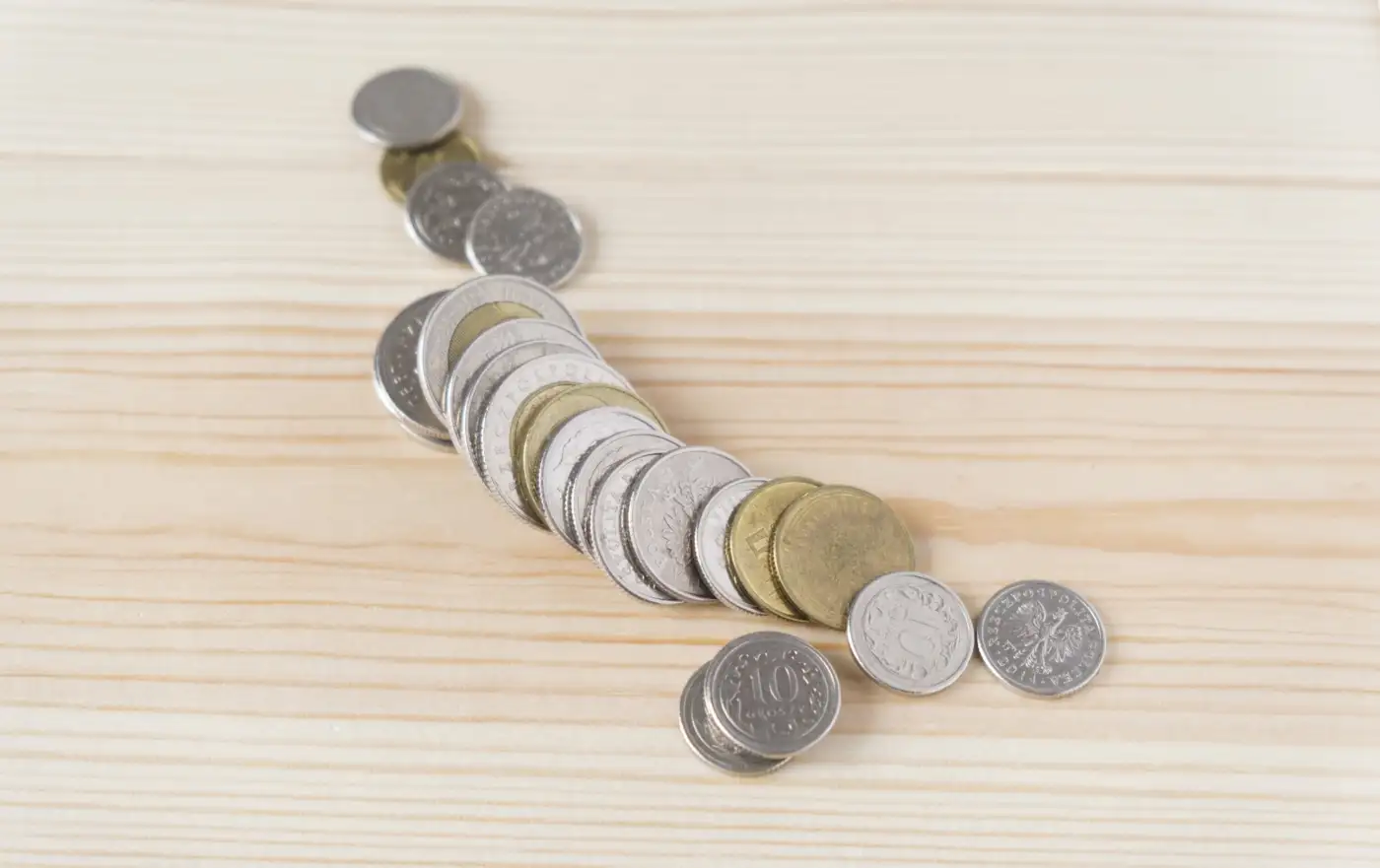 Coins spread across a wooden table