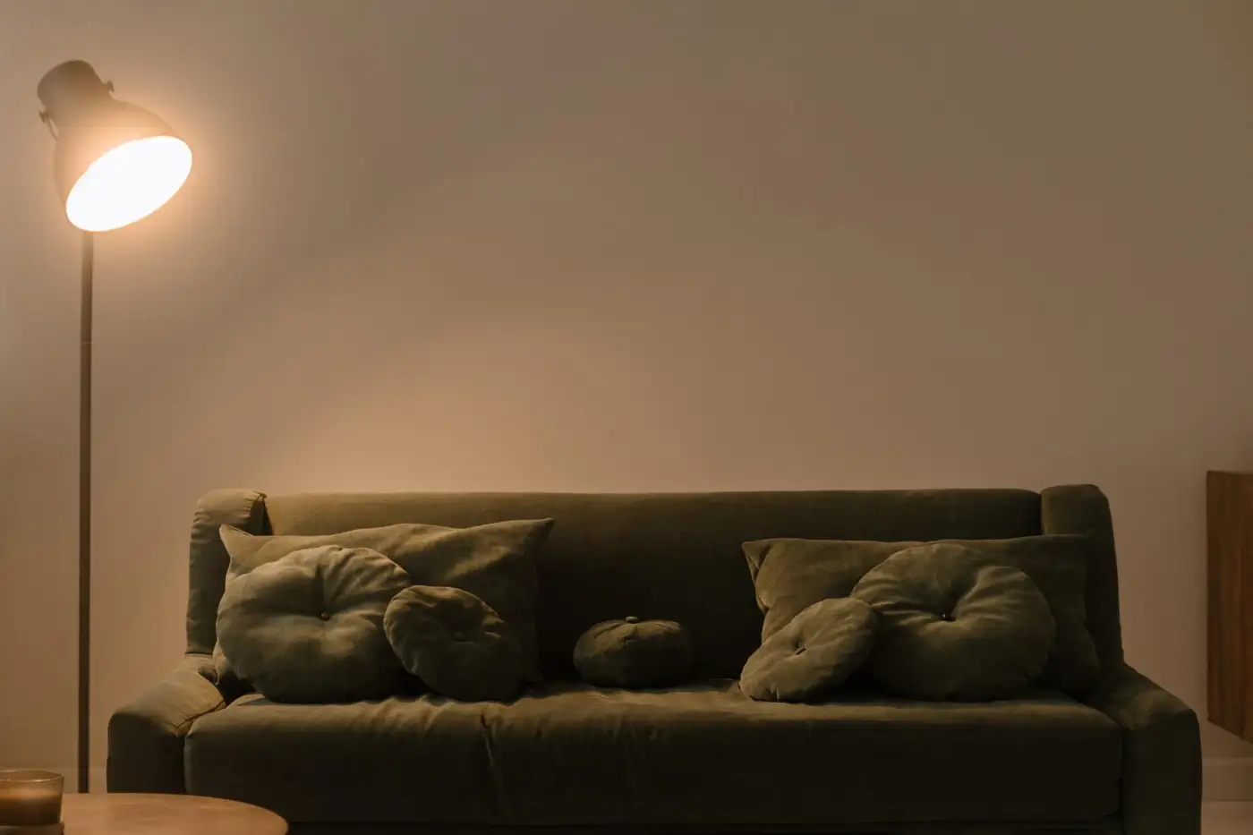 A sofa lit by a floor lamp in a quiet living room