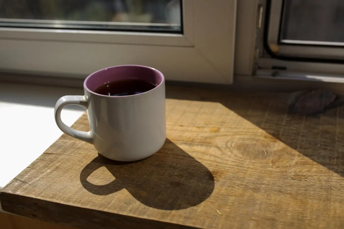 A mug of tea on a kitchen table in the sunlight