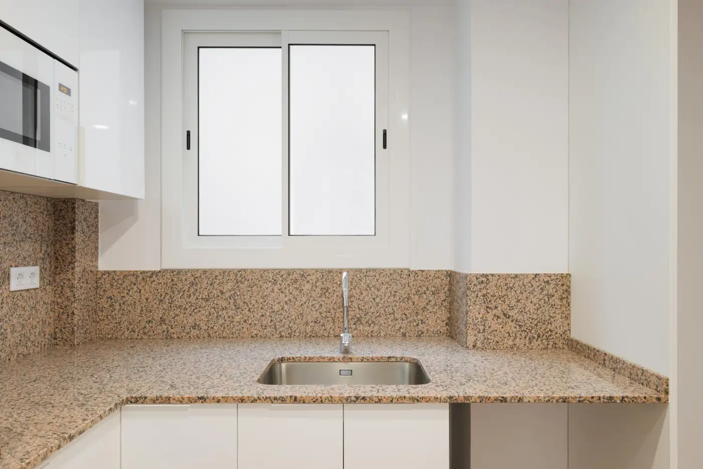 A kitchen lit by daylight from a sash window