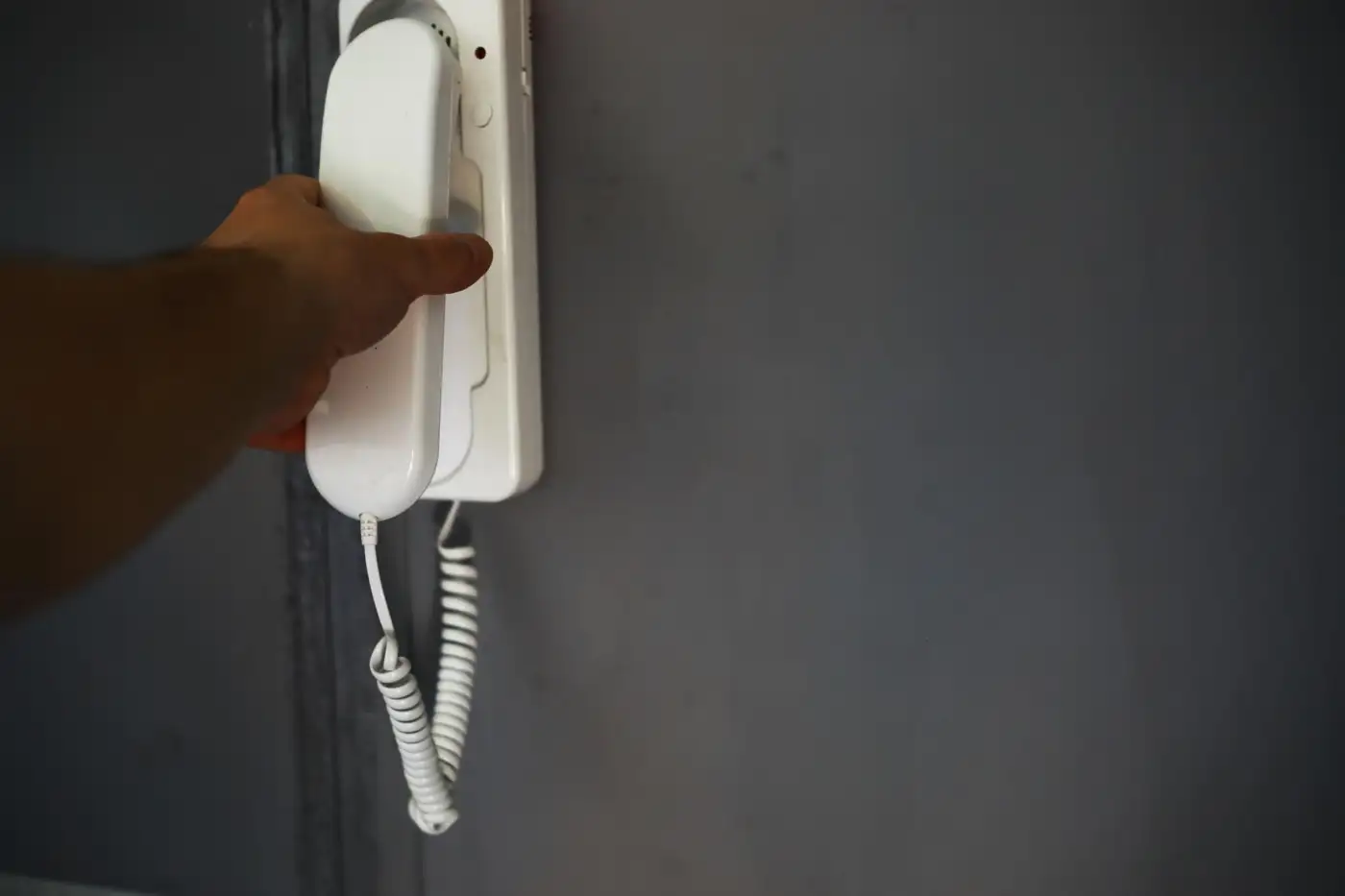 A hand lifting a telephone receiver