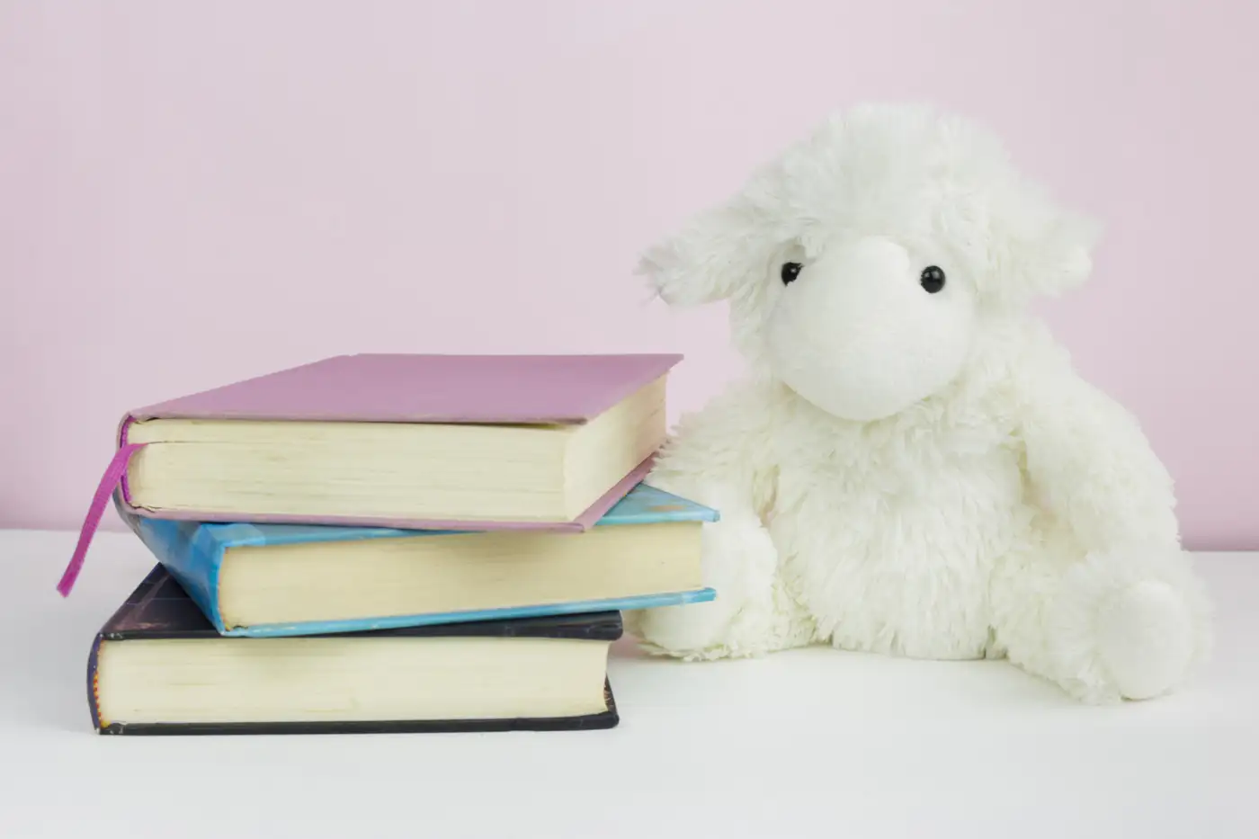 A soft toy beside a small stack of books