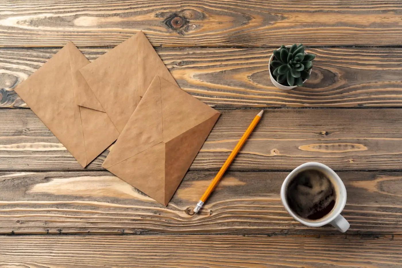 Brown envelopes and a pencil on a wooden table