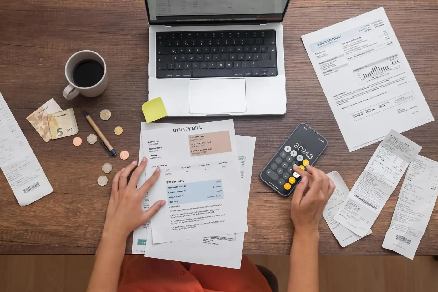Household bills, receipts and a calculator seen from above