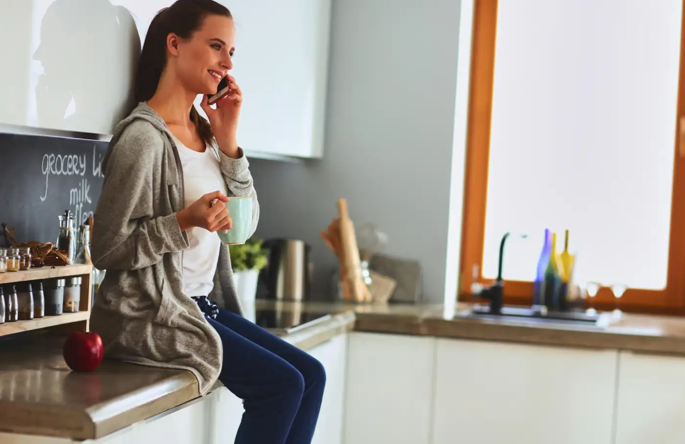 A woman on the phone in her kitchen