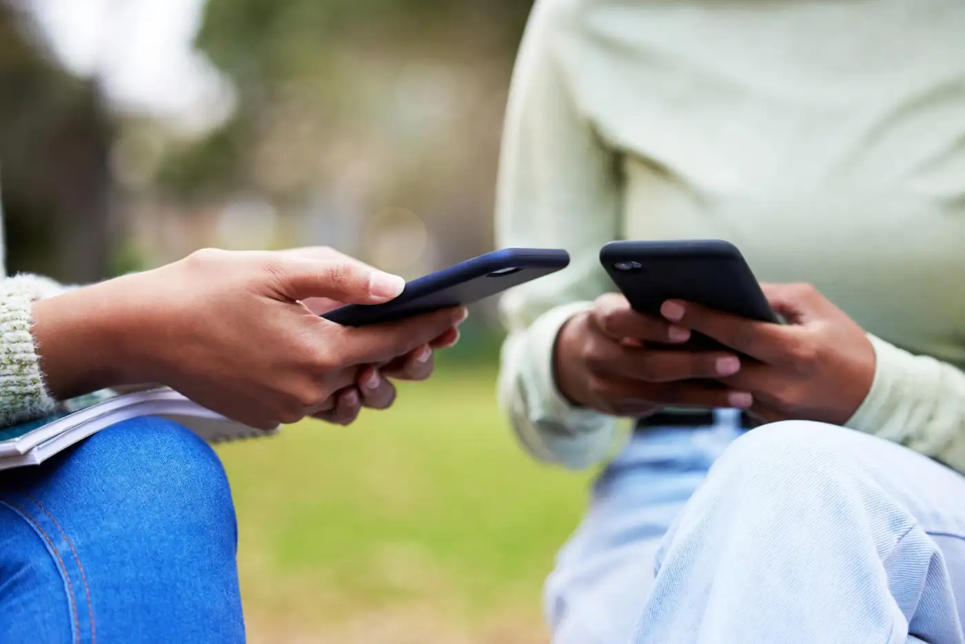 Close-up of hands typing on a smartphone