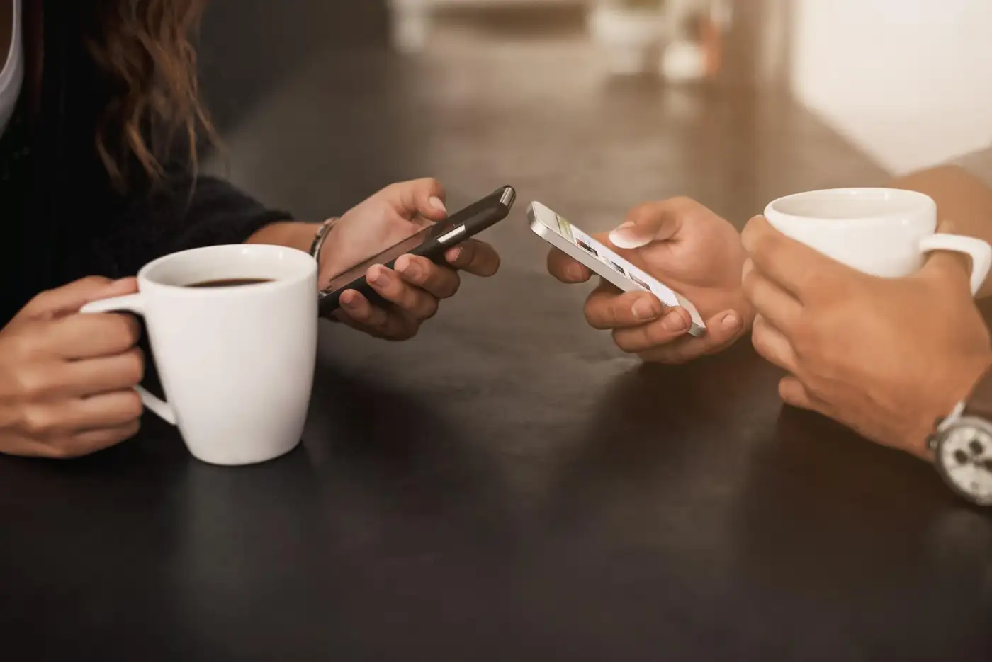 Hands holding a smartphone on a kitchen counter