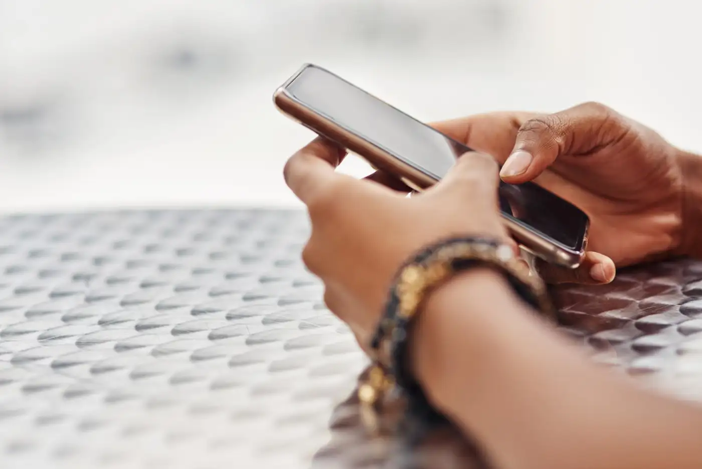 Hands holding a phone to send a text message