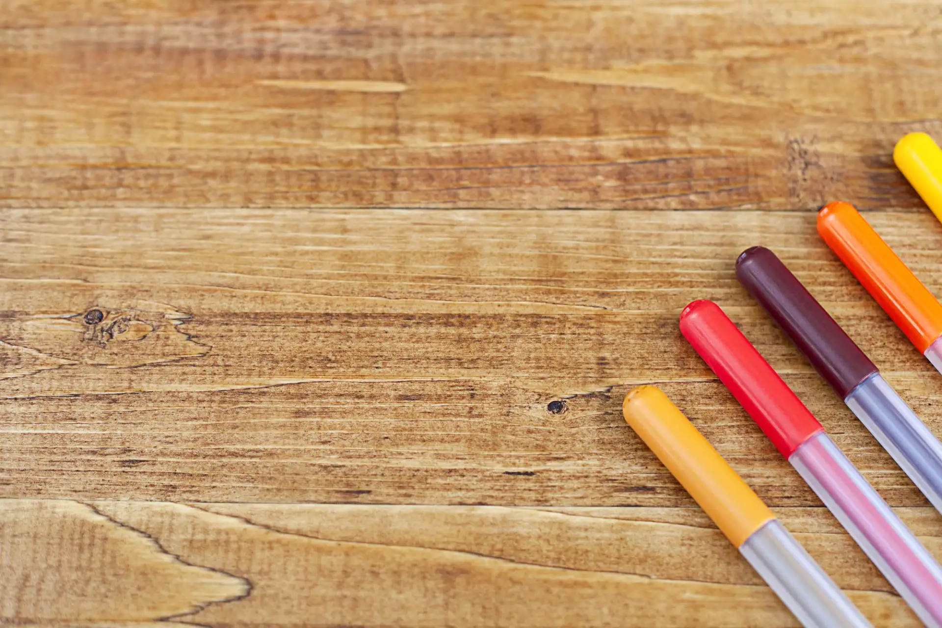 Coloured felt-tip pens on a wooden table