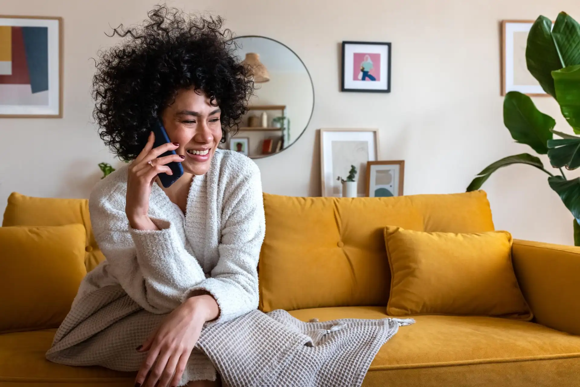 Smiling woman talking on her mobile phone at home